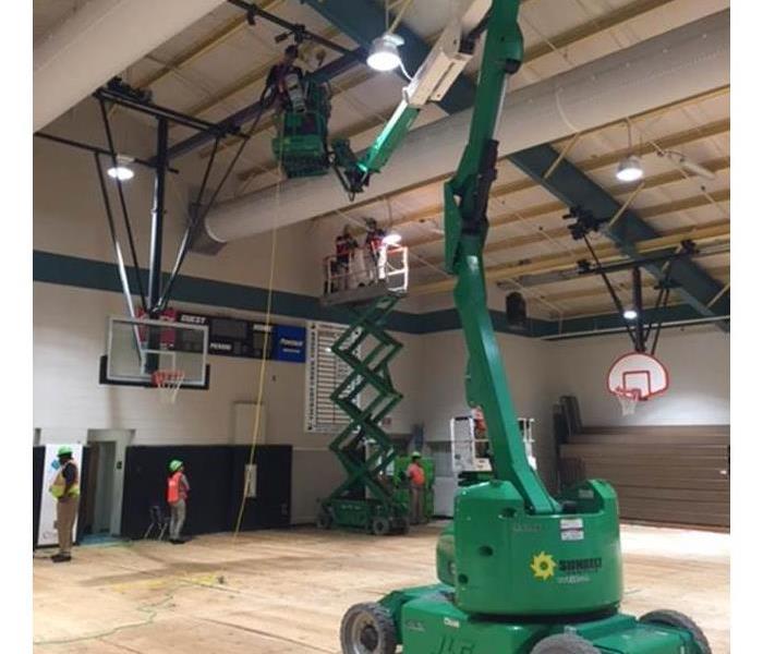 SERVPRO inside the gym of the school fixing a water leak