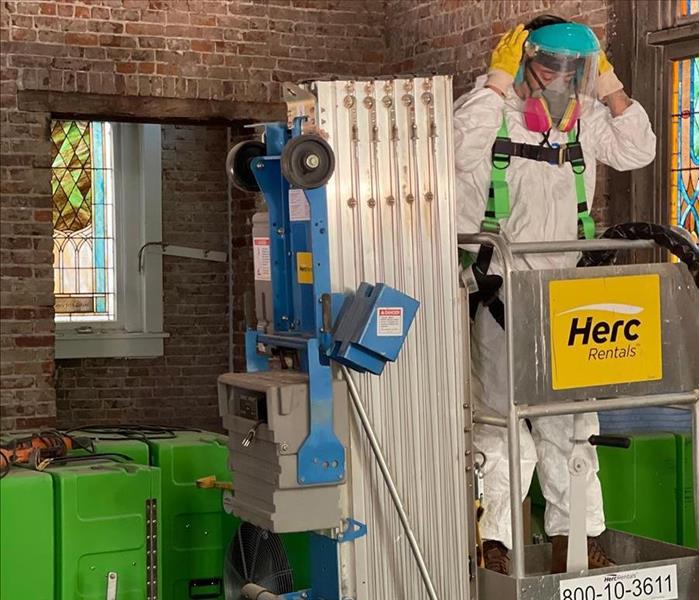 servpro employee in ppe on a lift