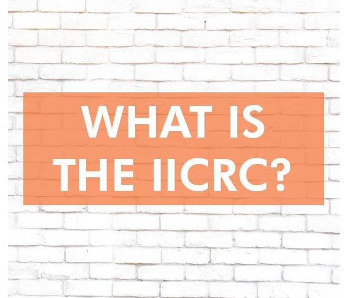 White brick wall with the words WHAT IS THE IICRC