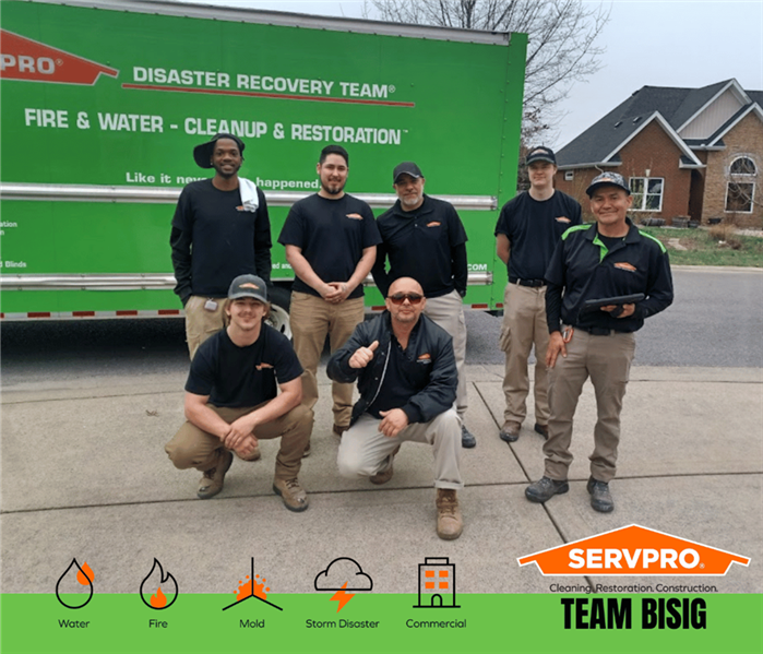 SERVPRO technicians posing in front of a SERVPRO truck for a photo after a successful water damage project
